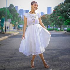 This exquisite Habesha dress is a true masterpiece of Ethiopian fashion. The dress is made from the finest handwoven Menen fabric, which is known for its softness, durability, and luxurious feel. The fabric is carefully crafted by skilled artisans using traditional weaving techniques that have been passed down through generations. The dress is a beautiful shade of white, which adds to its timeless elegance and sophistication. The simple yet stunning design of the dress allows the beauty of the f Eritrean Dress, Habesha Kemis, Flowing Skirt, Traditional Weaving, Shades Of White, Fitted Bodice, Weaving Techniques, Timeless Pieces, Timeless Elegance