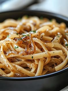 a black bowl filled with pasta on top of a table