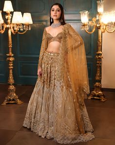 Ombre gold and silver bridal lehenga embellished with sequin, crystals, beads, cutdana embroidery, and a matching full-sleeved blouse in gold. The lehenga comes with a shaded embroidered cutwork dupatta.DELIVERY TIMEPlease allow 8-12 weeks for your outfit to arrive.FABRIC DETAILSNetProfessional cleaning only. Gold Bollywood Designer Lehenga, Bollywood Style Designer Gold Lehenga, Gold Embellished Choli, Gold Lehenga With Dupatta For Reception, Gold Designer Wear Lehenga With Traditional Drape, Gold Choli With Dupatta For Reception, Embellished Gold Choli, Bollywood Style Gold Embellished Choli, Elegant Gold Lehenga With Mirror Work