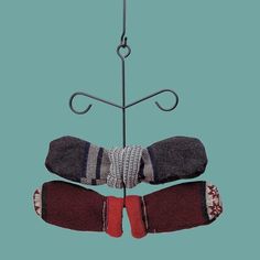 two pairs of mitts hanging from a hook