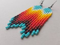 a pair of colorful beaded earrings with black hooks