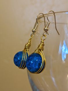 These beautiful earrings are hand made from gold colored beading wire. This lovely design holds a single gorgeous blue glass bead. These earrings are light and comfortable. I find that these earrings have a versatile look perfect for any occasion. The single blue bead adorned with gold looks absolutely divine. I hope you enjoy them as much as I enjoyed making them. They are designed with 22 gauge wire so they can bend if not treated with care. I have provided pictures for size reference, so please look through those for measurements. I make several pairs of earrings with the exact wire and beads. Each pair is unique to each other, numbered, and cataloged. The pictures shown is of the exact pair that will be shipped. These earrings also come with clear earring backs. The backings are silico Wire Wrap Earrings, Clear Earrings, Wrap Earrings, Wire Wrapped Earrings, Beading Wire, Earrings Blue, Blue Beads, Earring Backs, Wire Wrap