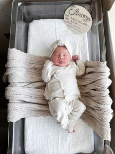 a baby is laying in a clear box with white blankets on it's sides