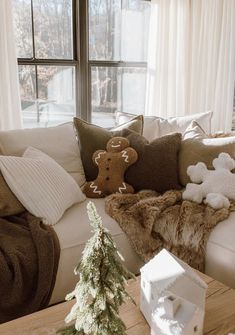 a living room filled with furniture and a christmas tree in front of a large window