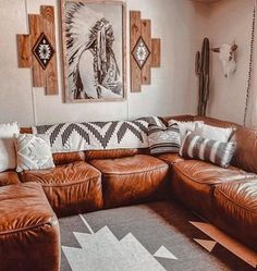 a living room with brown leather couches and native american artwork on the wall above