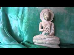 a buddha statue sitting on top of a green cloth