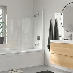 a bathroom with a sink, mirror and bathtub next to a window in it