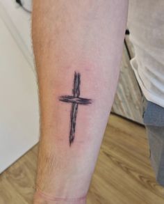 a person with a cross tattoo on their leg