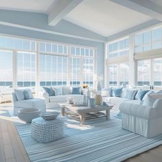 a living room filled with white furniture and large windows covered in blue shades on the walls