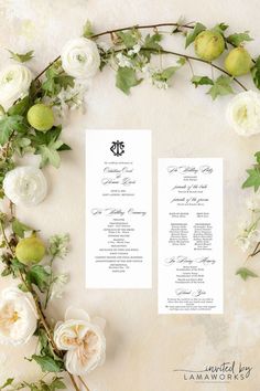 two wedding programs with white flowers and greenery