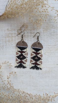 the earrings are made with seed beads and beaded in brown, white and black