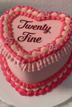 a heart shaped cake with the words twenty fine written on it's side and pink icing