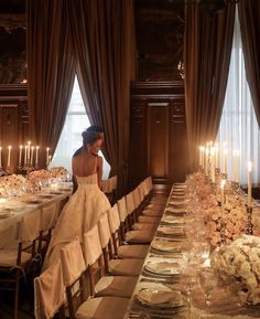 a woman sitting at a long table in front of candles