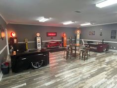 a room with several different types of furniture and lights on the walls, along with two bar stools