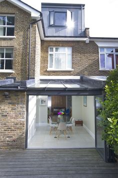 an open door leading to a house with a table and chairs in the middle of it