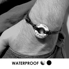 a man wearing a black and white bracelet with the words waterproof written on it