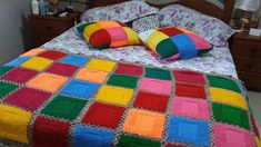 a bed with colorful blankets and pillows on it