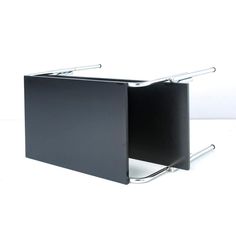 a black binder with two metal handles on it's sides and a white wall in the background