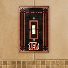 a chicago bears light switch plate cover on a wall in a bathroom with brown tile