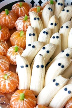 some peeled bananas and oranges with black dots on them are arranged in a bowl