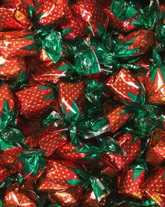 a pile of wrapped christmas presents sitting on top of each other in green and red wrappers