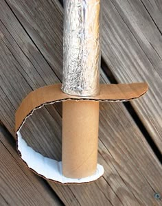 a roll of tin foil is wrapped around a toilet paper holder on a wooden deck