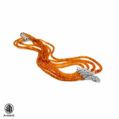 "This gorgeous diamond and 18kt white gold pendant suspended by four strands of Orange Garnet, faceted beads, and completed with a 18kt white gold and diamond clasp. This stunning garnet necklace is from our \"vintage\" Collection. It is circa 2000 and in a good condition. [MATERIALS] Stones: Diamonds (98) Carat: 0.93 Clarity: SI1 Color: H-I Cut: Round Setting: Pave Measurement of the center piece: 52.40 mm x 23.55 mm The chain is made up of 289.31 ct orange Garnets faceted beads The measurement Elegant Orange Necklaces With Polished Beads, Elegant Orange Jewelry With Faceted Beads, Luxury Orange Gemstone Beaded Necklace, Vintage Orange Beaded Necklace, Orange Gemstone Vintage Necklace, Antique Orange Necklace With Polished Beads, Orange Vintage Necklace With Faceted Beads, Luxury Multi-strand Gemstone Beads Jewelry, Luxury Multi-strand Gemstone Beads Necklace