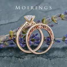 two wedding rings sitting next to each other on top of purple flowers with the words mohriings written above them