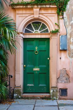 A green front door with brass accents stands out against a tan house with peeling paint, showcasing an outdoor house paint renovation facade. Black Front Door Colors, Tan Color Palette, Black Front Door, Color Theory Art, Green Front Doors