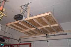 an overhead view of a garage with red cabinets and metal equipment hanging from the ceiling