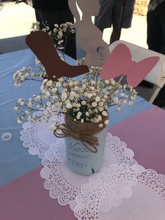 a vase filled with baby's breath flowers on top of a pink and blue table