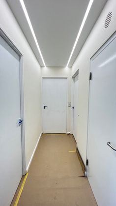 an empty room with two white doors and some yellow tape on the floor next to it