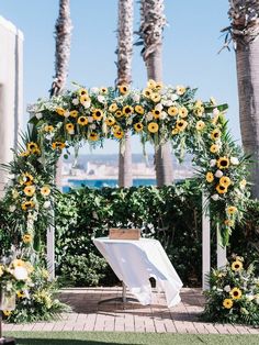 an outdoor ceremony setup with sunflowers and greenery