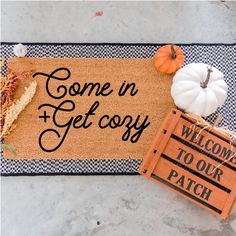 a welcome mat with some pumpkins on it