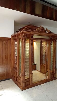 an ornate wooden room divider in the middle of a tiled floored area with wood paneling