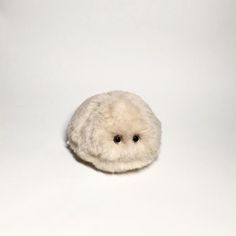 a small white stuffed animal sitting on top of a table