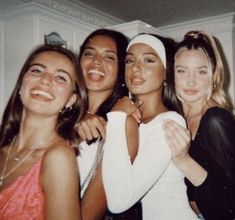 four young women posing for the camera with one holding her arm around another woman's neck