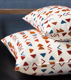 two decorative pillows on top of each other