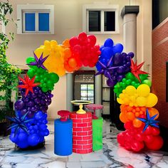 an arch made out of balloons in the shape of stars and rainbows is on display