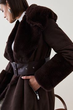 A Coat From Another Era. Defined By Plush Faux Shearling At The Collar And Cuffs, This Sumptuous Cover-Up Is Both Touchably Soft And Undeniably Fashionable. It Features A Large Buckled Belt To Draw In The Silhouette Along With Diagonal Silver-Tone Zips To Stow Cold Hands On Chilly Winter Walks. Fitted Long Coat With Belt, Chic Winter Outerwear With Belt Loops, Fitted Winter Outerwear With Belt Loops, Brown Belted Winter Outerwear, Belted Long Sleeve Fur Coat For Fall, Belted Brown Outerwear For Winter, Winter Long Coat With Belt Loops, Winter Long Coat With Self Belt, Fitted Belted Fur Coat For Fall