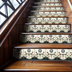 the stairs are decorated with floral tiles and wooden handrails, along with wood flooring