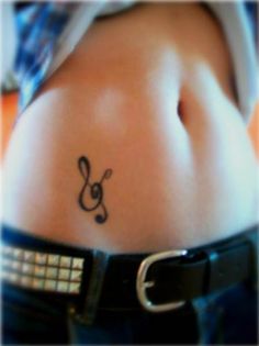 a woman's belly with a music note tattoo on it