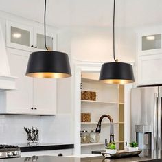 two pendant lights hanging over a kitchen island