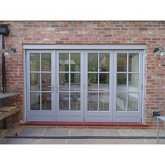 an image of a patio with french doors on the outside and brick building in the background