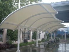 an outdoor covered parking lot with bikes parked under it