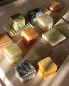 several different types of soaps sitting on the floor next to each other with shadows