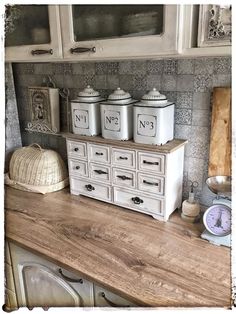 a kitchen counter with white cabinets and drawers