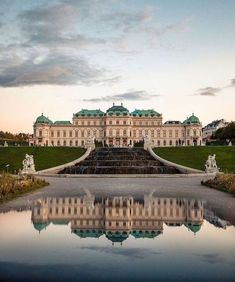 a large building with a fountain in front of it and some water on the ground