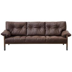 a brown leather couch sitting on top of a wooden frame