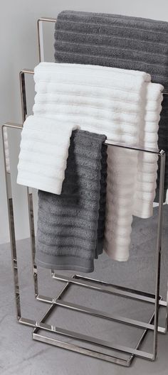 several folded towels are stacked in a metal holder